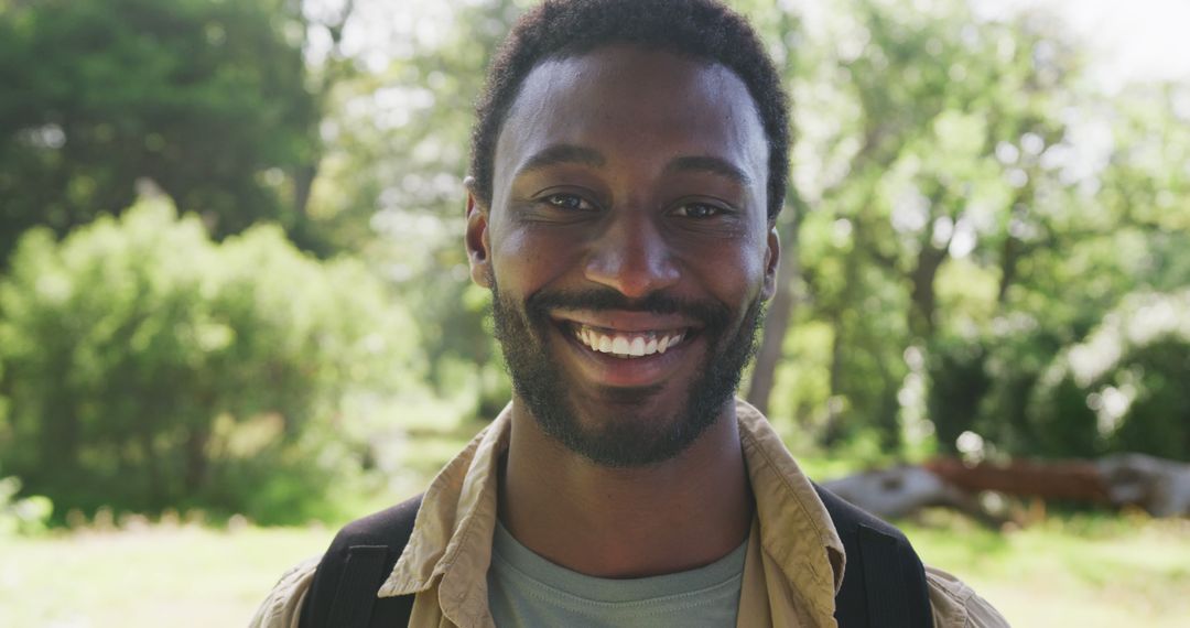 Happy African American Man Smiling in Lush Park - Free Images, Stock Photos and Pictures on Pikwizard.com