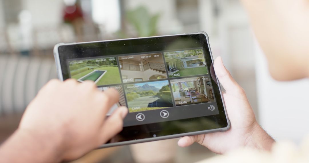 Man Using Tablet and Examining Home Surveillance Camera Footage Indoors - Free Images, Stock Photos and Pictures on Pikwizard.com