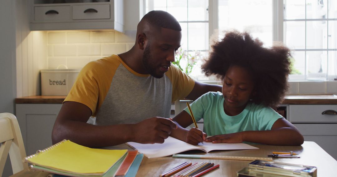 Father Helping Daughter with Homework at Kitchen Table - Free Images, Stock Photos and Pictures on Pikwizard.com