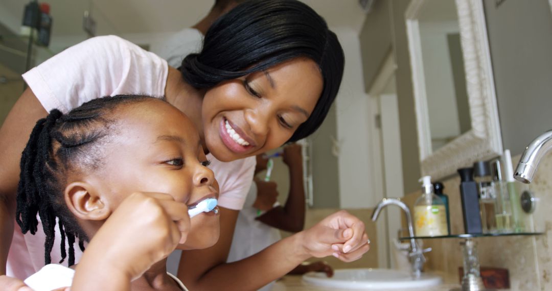 Young African American Woman Teaching Child to Brush Teeth at Home - Free Images, Stock Photos and Pictures on Pikwizard.com