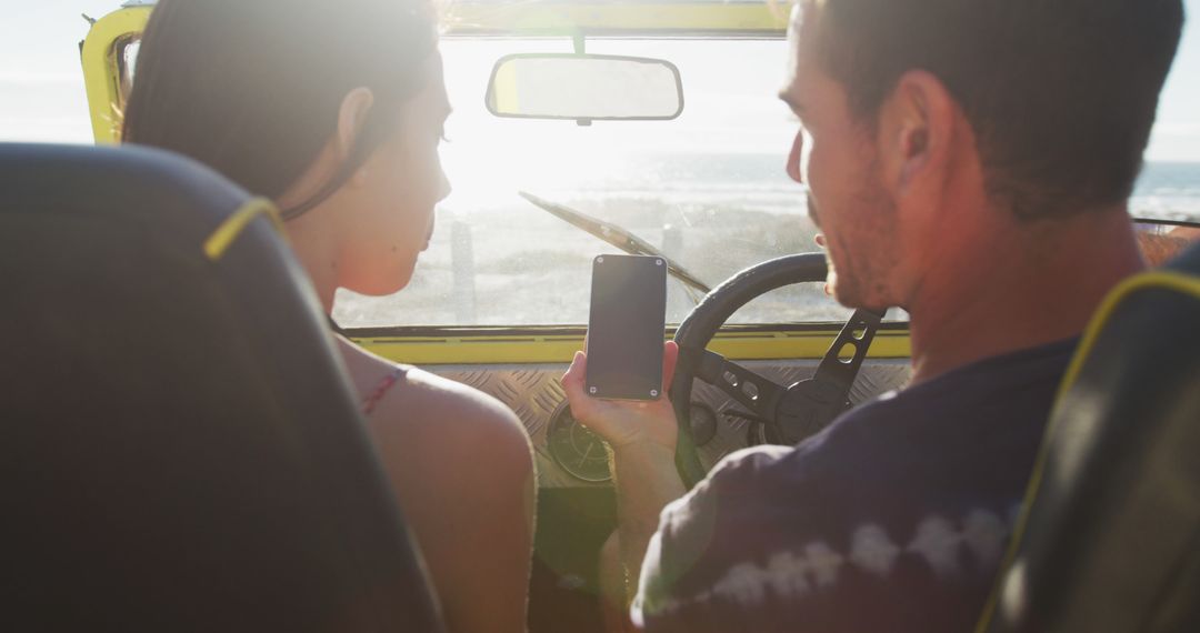 Couple Enjoying Scenic Drive in Beach Buggy Using Smartphone