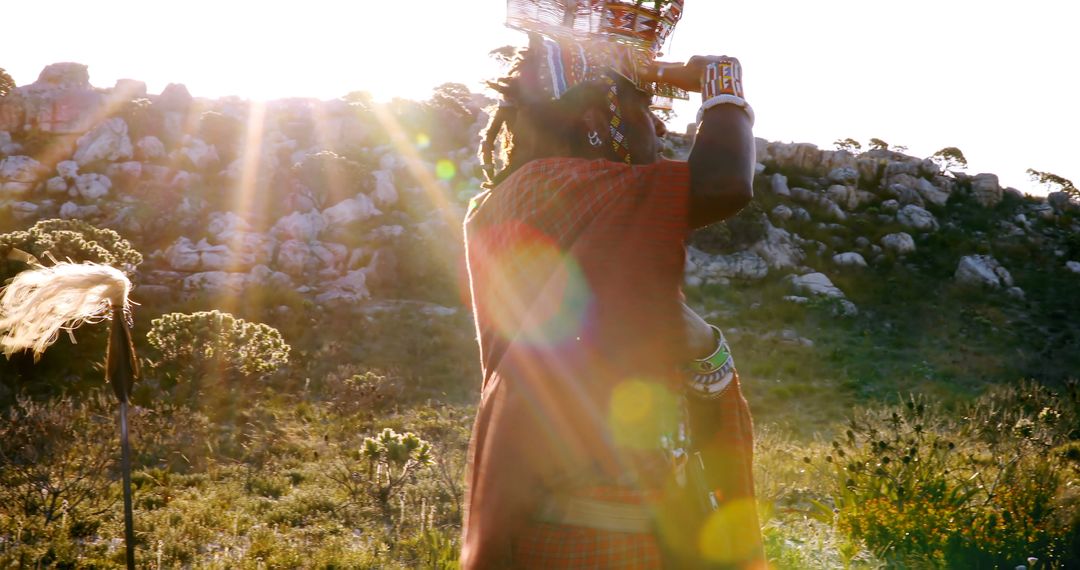 Maasai Warrior in Traditional Attire Carrying Basket in Morning Light - Free Images, Stock Photos and Pictures on Pikwizard.com