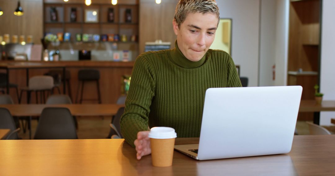 Woman Working on Laptop in Cafe with Hot Drink - Free Images, Stock Photos and Pictures on Pikwizard.com