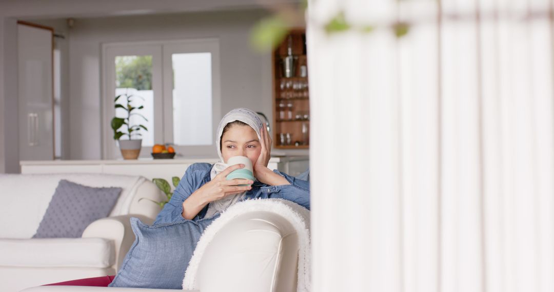 Young Woman Relaxing on Couch Drinking Hot Beverage - Free Images, Stock Photos and Pictures on Pikwizard.com