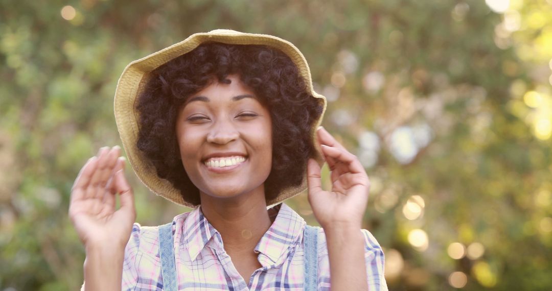 Joyful African American Woman Enjoying Nature in Straw Hat - Free Images, Stock Photos and Pictures on Pikwizard.com