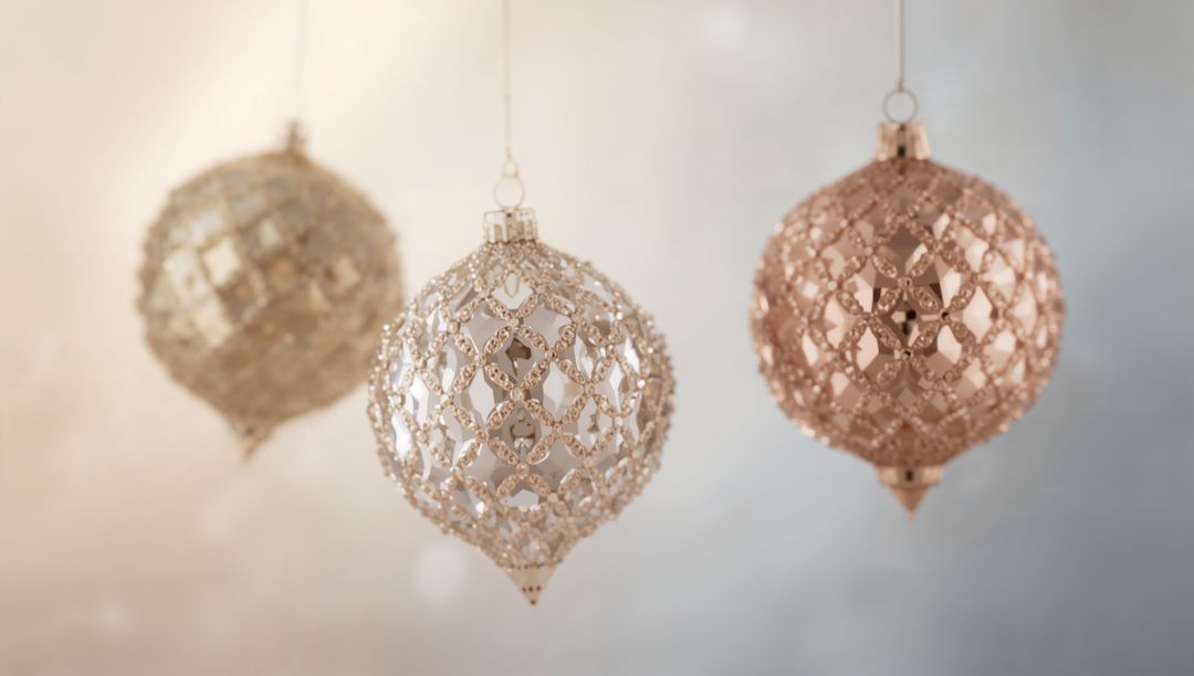 Hanging metallic filigree baubles in champagne, rose gold and silver with soft bokeh glow