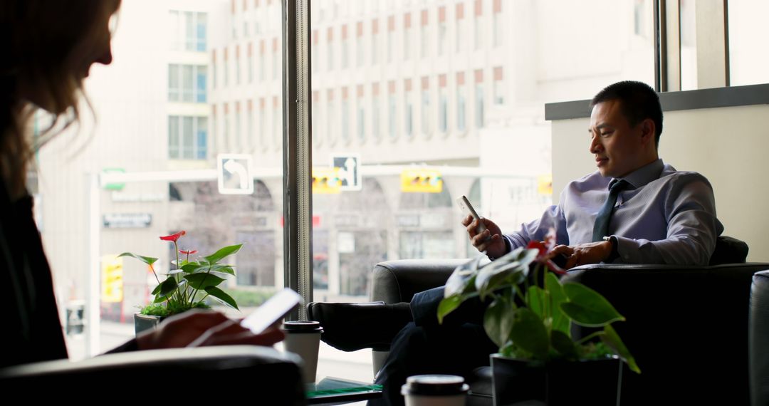 Businessman Using Mobile Phone in Modern Hotel Lobby