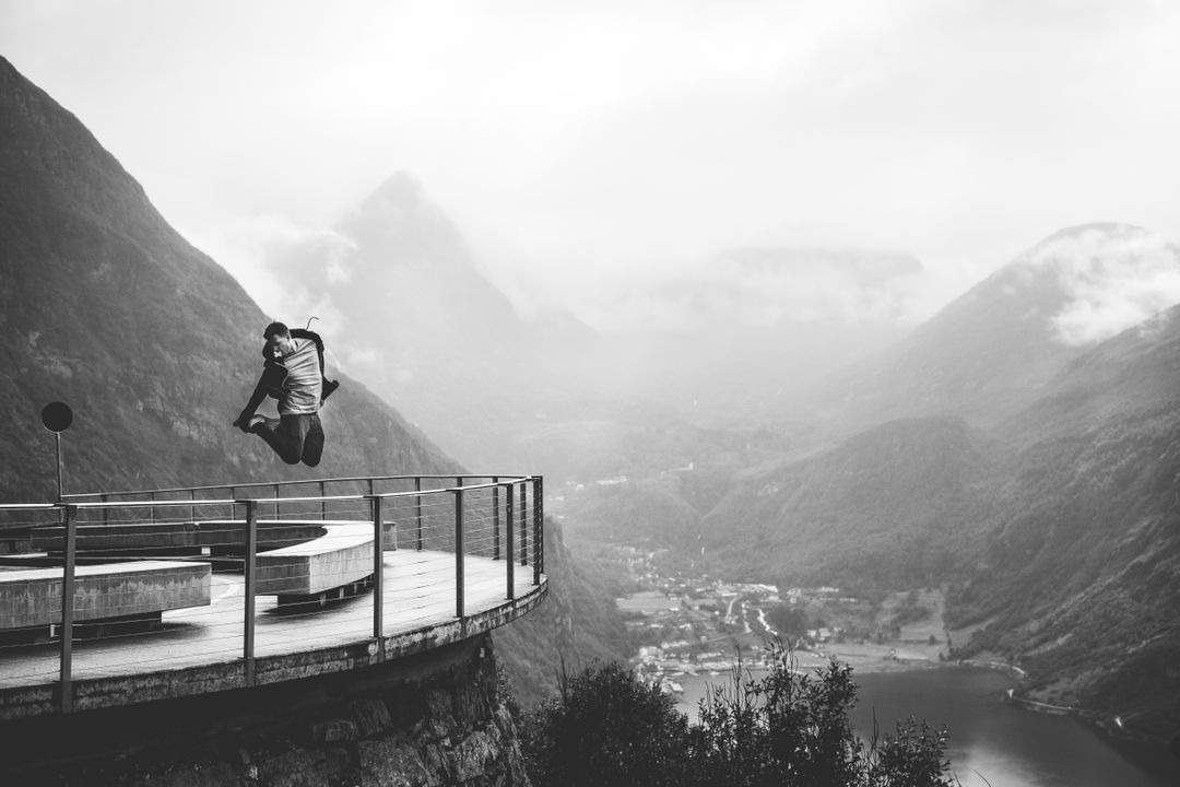 Man Jumping with Scenic Mountain View in Background in Black and White - Free Images, Stock Photos and Pictures on Pikwizard.com