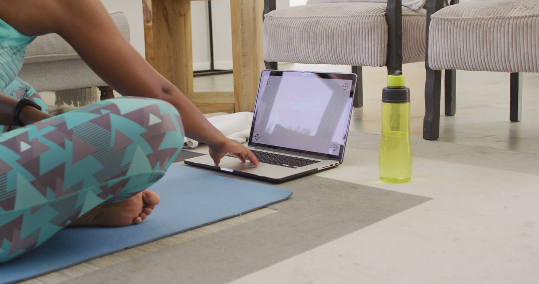 Woman Practicing Yoga Indoors with Laptop and Water Bottle - Free Images, Stock Photos and Pictures on Pikwizard.com