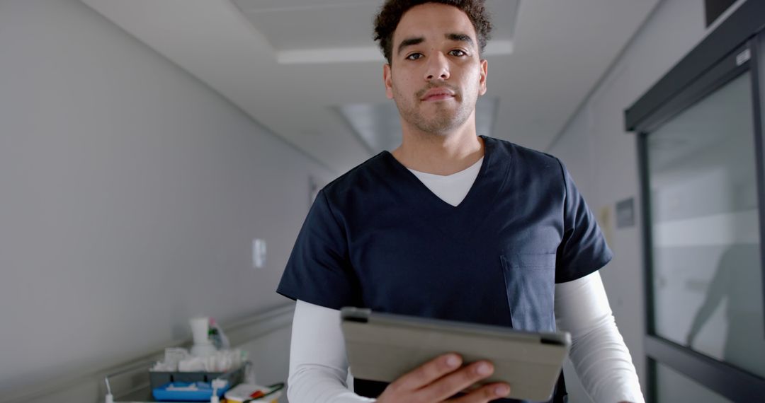 Male Nurse Holding Tablet in Hospital Corridor - Free Images, Stock Photos and Pictures on Pikwizard.com