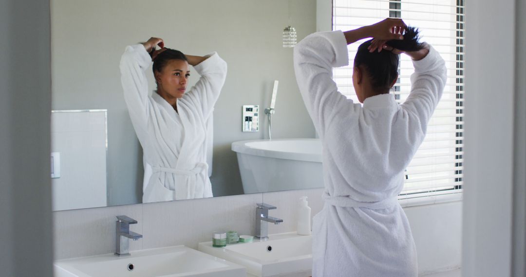 Woman Preparing Hair in Modern Bathroom Mirror - Free Images, Stock Photos and Pictures on Pikwizard.com