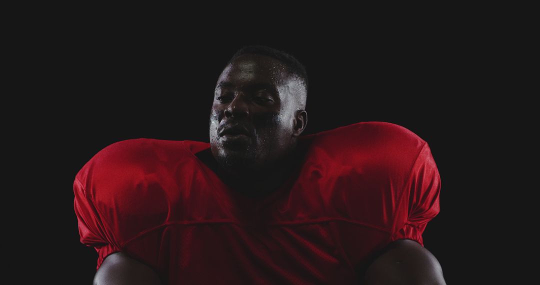 Confident African American Football Player Posing Spotlit - Free Images, Stock Photos and Pictures on Pikwizard.com