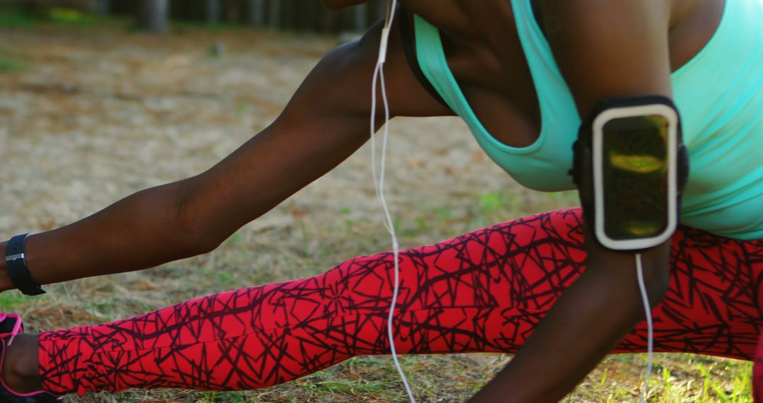 Woman Stretching in Red Patterned Leggings Listening to Music - Free Images, Stock Photos and Pictures on Pikwizard.com