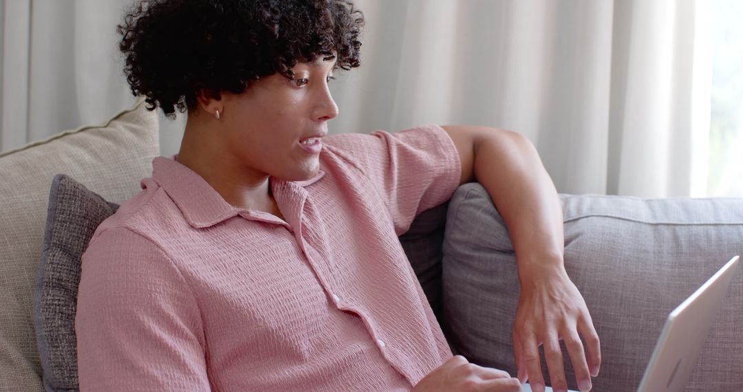 Man Engaged with Laptop on Sofa Showing Casual Relaxation