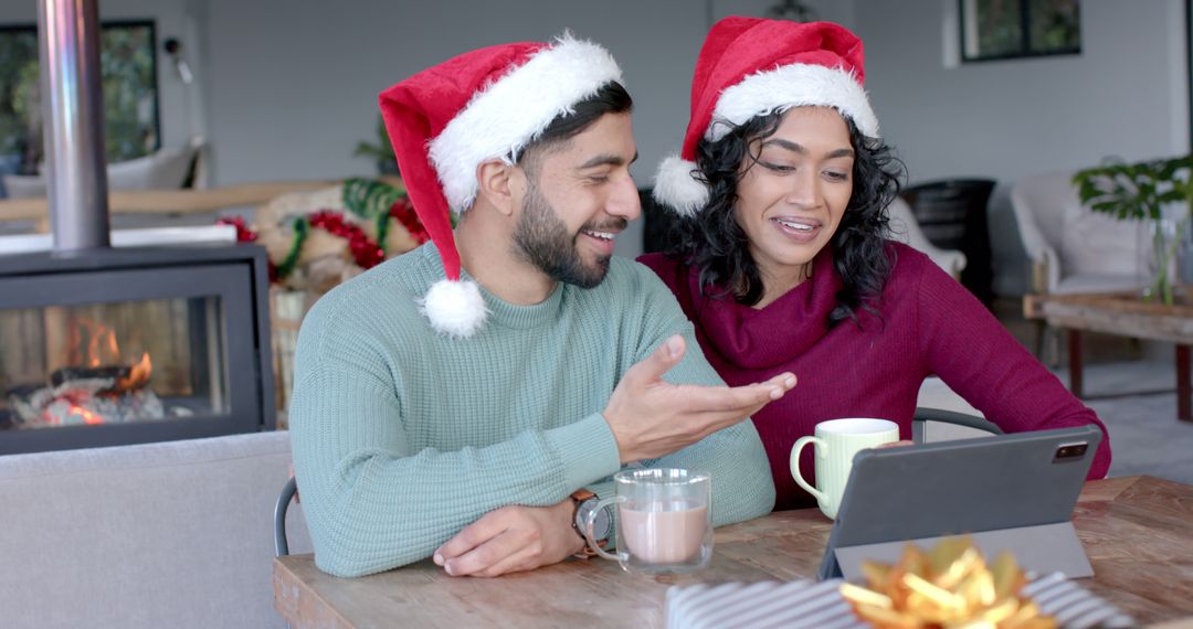 Happy Couple Wearing Santa Hats Video Calling for Christmas Celebration - Free Images, Stock Photos and Pictures on Pikwizard.com