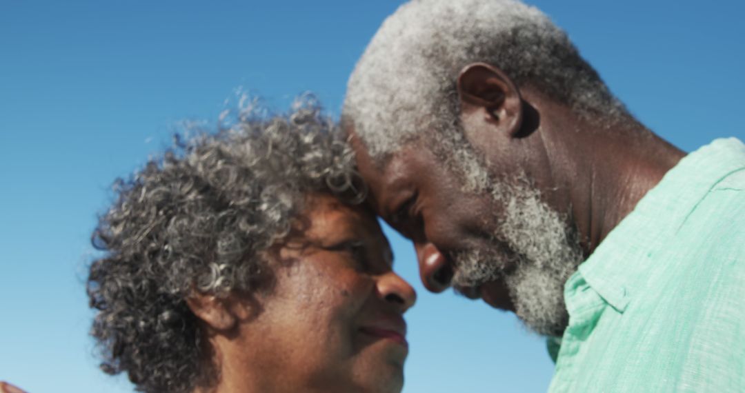 Senior Couple Embracing Outdoors Against Clear Blue Sky - Free Images, Stock Photos and Pictures on Pikwizard.com