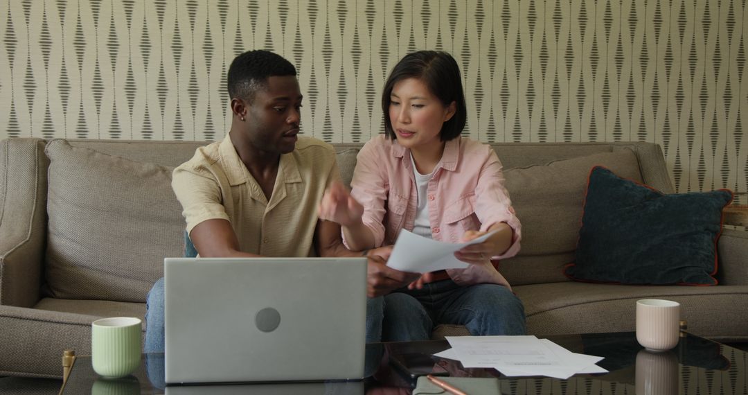 Couple Together Managing Finances With Laptop and Documents