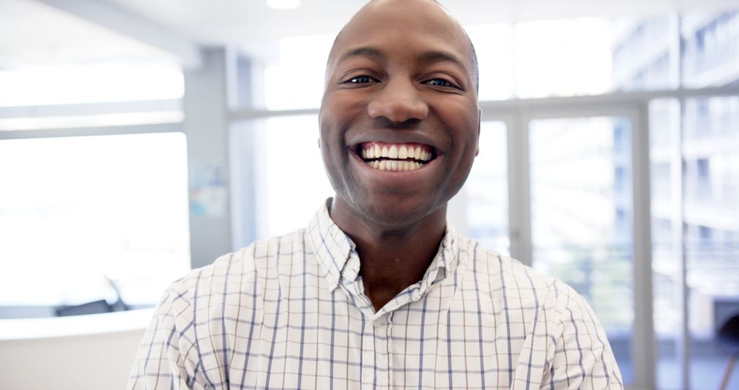 Smiling African American Man in Checkered Shirt at Modern Office - Free Images, Stock Photos and Pictures on Pikwizard.com