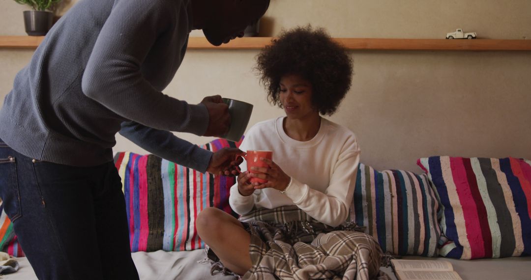 Diverse Couple Enjoying Coffee Together at Home on Cozy Couch