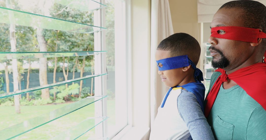 Father and Son Wearing Superhero Costumes Looking Out Window - Free Images, Stock Photos and Pictures on Pikwizard.com