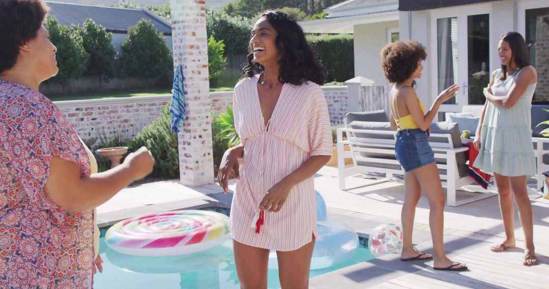 Laughing friends enjoying backyard plunge pool party on sunny patio with colorful float