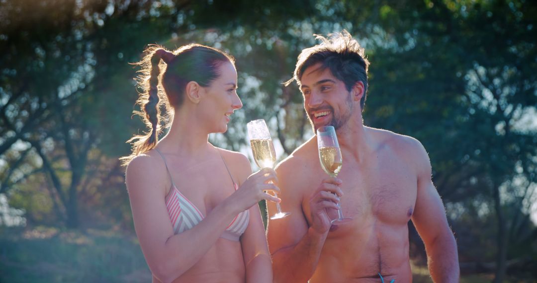 A couple celebrates a special occasion outdoors with champagne in a serene setting. - Free Images, Stock Photos and Pictures on Pikwizard.com