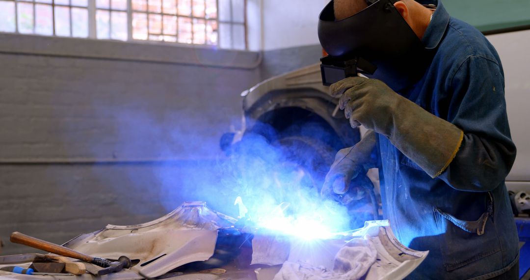 Skilled Worker Welding Metal in Workshop with Sparks Under Protection - Free Images, Stock Photos and Pictures on Pikwizard.com