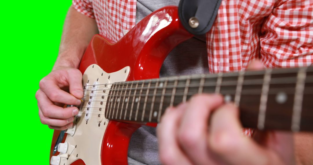 Close-up of person playing red electric guitar against green screen - Free Images, Stock Photos and Pictures on Pikwizard.com