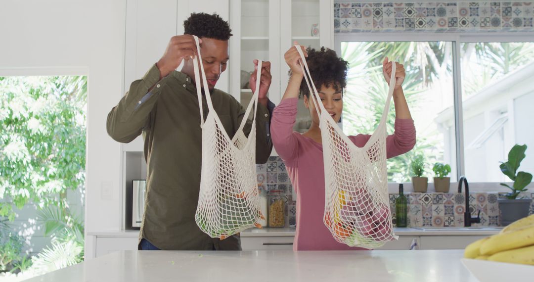 Couple Unpacking Groceries in Kitchen Using Reusable Bags - Free Images, Stock Photos and Pictures on Pikwizard.com