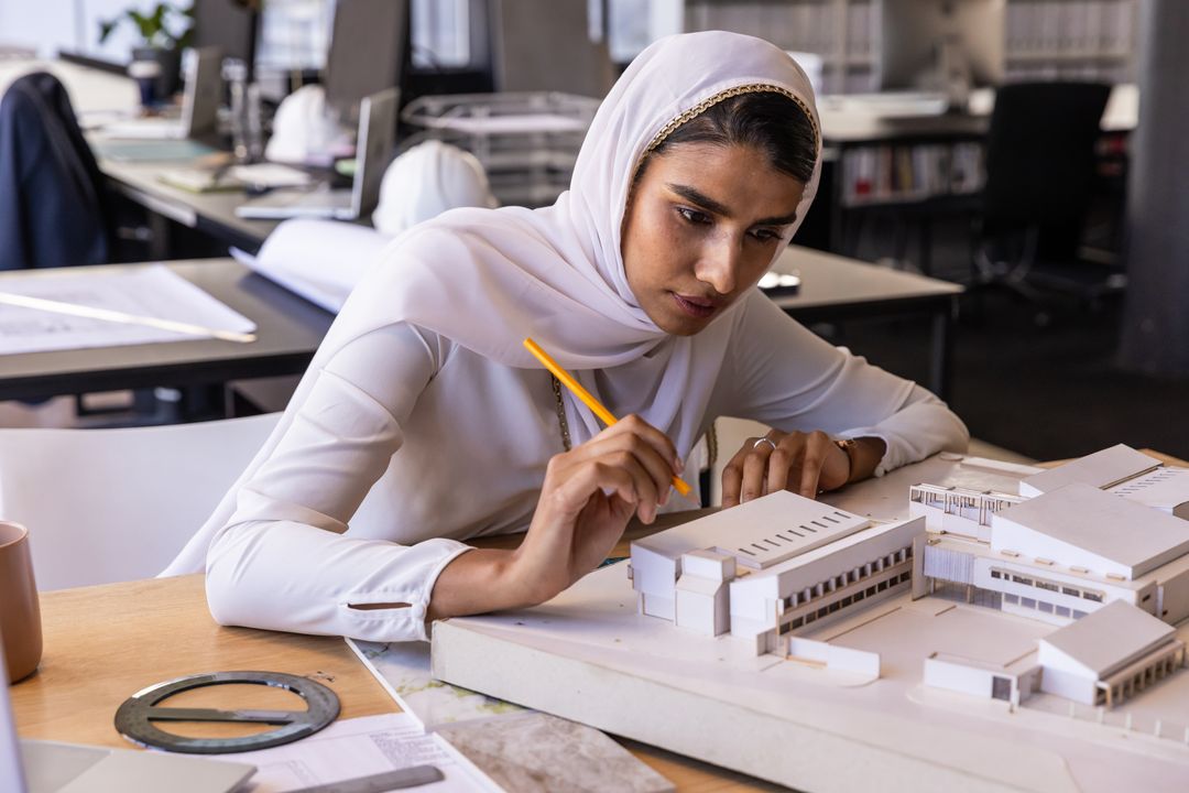 Architect Woman Enhancing Scale Model Designs in Workspace