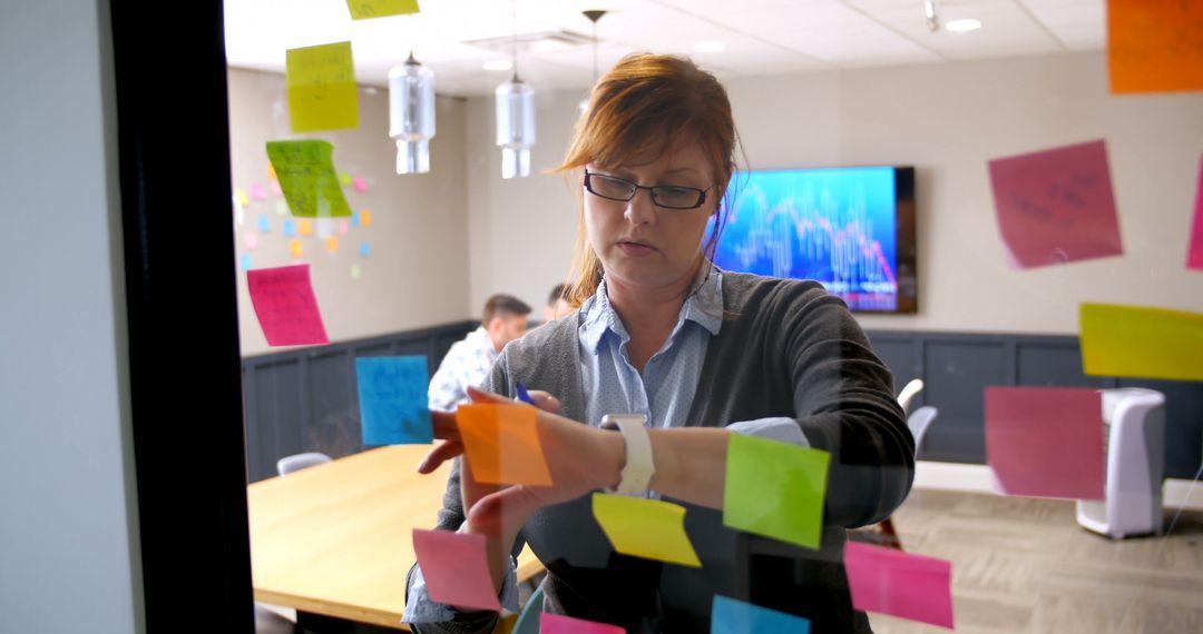 Female Professional Brainstorming with Sticky Notes in Office