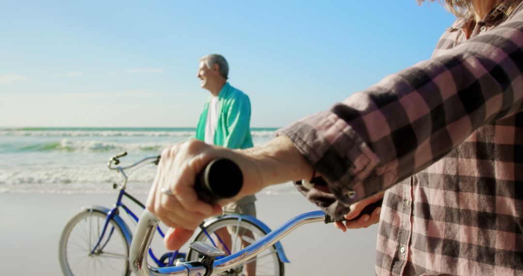 Senior Couple Enjoying Bicycle Ride on Beachside Shoreline
