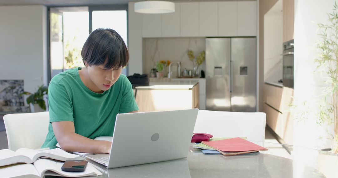 Asian Student Studying at Home with Laptop and Books