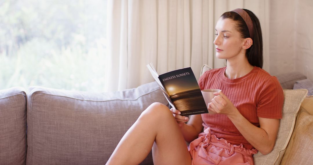 Woman Relaxing at Home Reading Book and Drinking from Mug