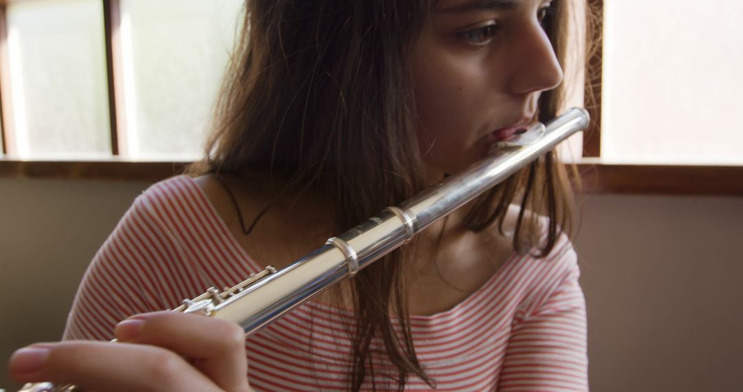 Young Woman Playing Flute in Natural Light - Free Images, Stock Photos and Pictures on Pikwizard.com