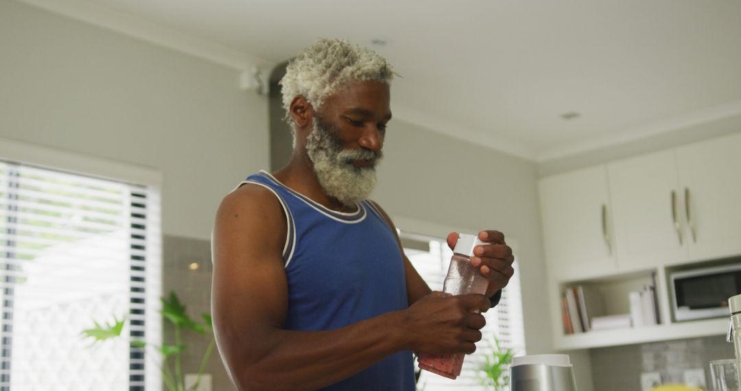 Image of happy african american senior man preparing smoothie - Free Images, Stock Photos and Pictures on Pikwizard.com