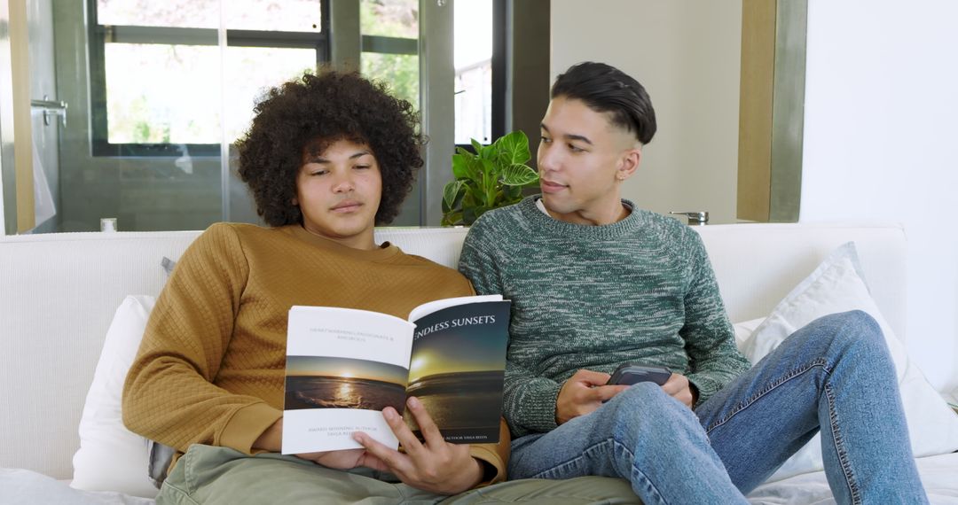 Diverse Friends Relaxing with Book and Smartphone on Cozy Sofa
