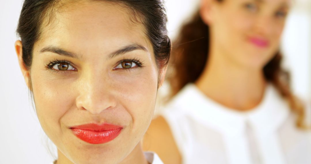 Confident Woman Smiling with Blurred Female Colleague in Background - Free Images, Stock Photos and Pictures on Pikwizard.com