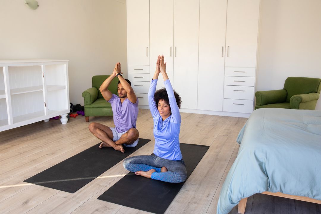 Diverse Couple Practicing Yoga Poses on Black Mats in Home