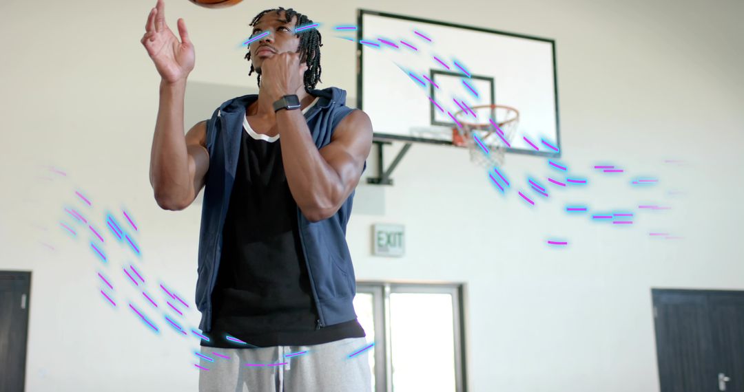 Young basketball player tossing ball with neon motion trails at indoor court and hoop