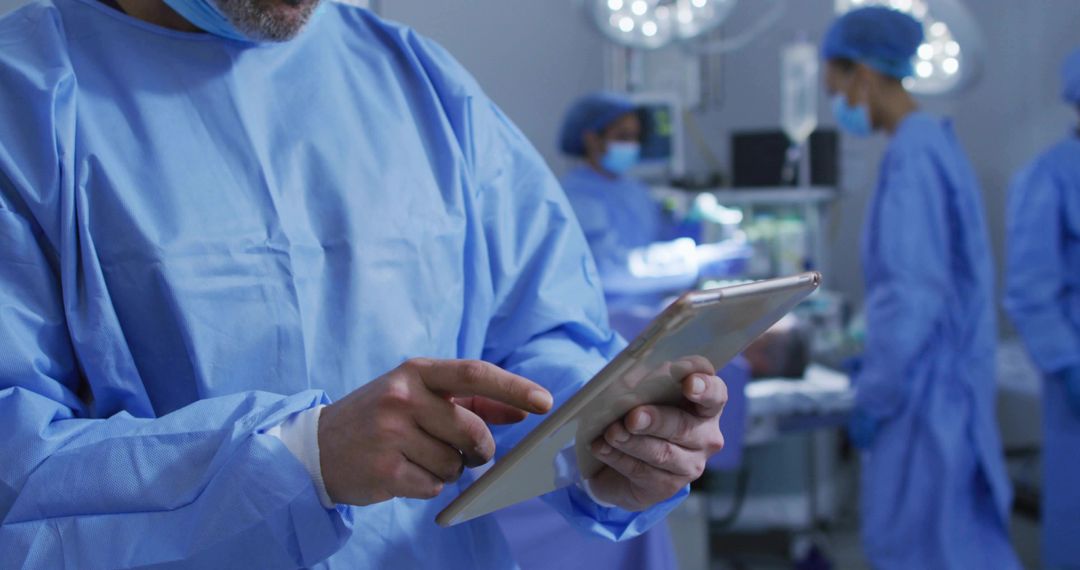 Surgeon Reviewing Tablet Data while Leading Surgical Team in Modern Operating Room