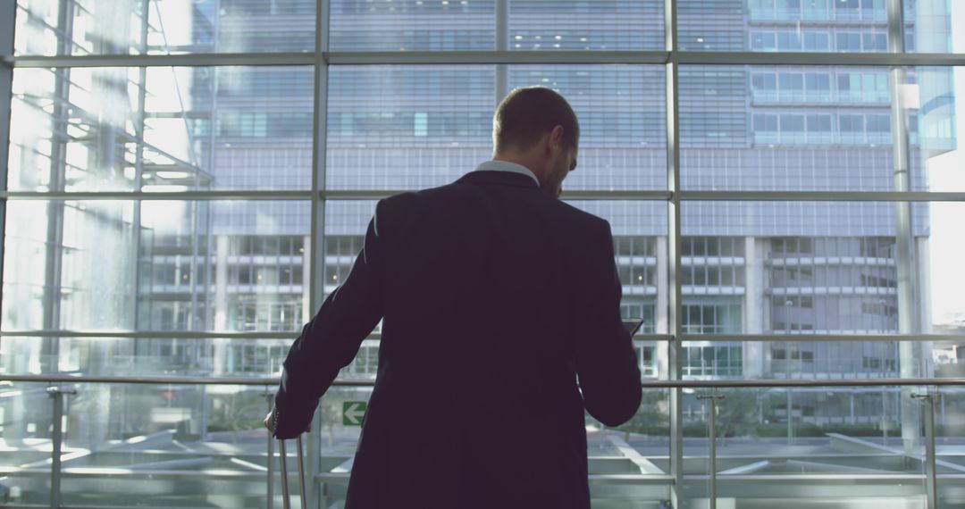 Businessman Looking Out at Modern Office Building - Free Images, Stock Photos and Pictures on Pikwizard.com