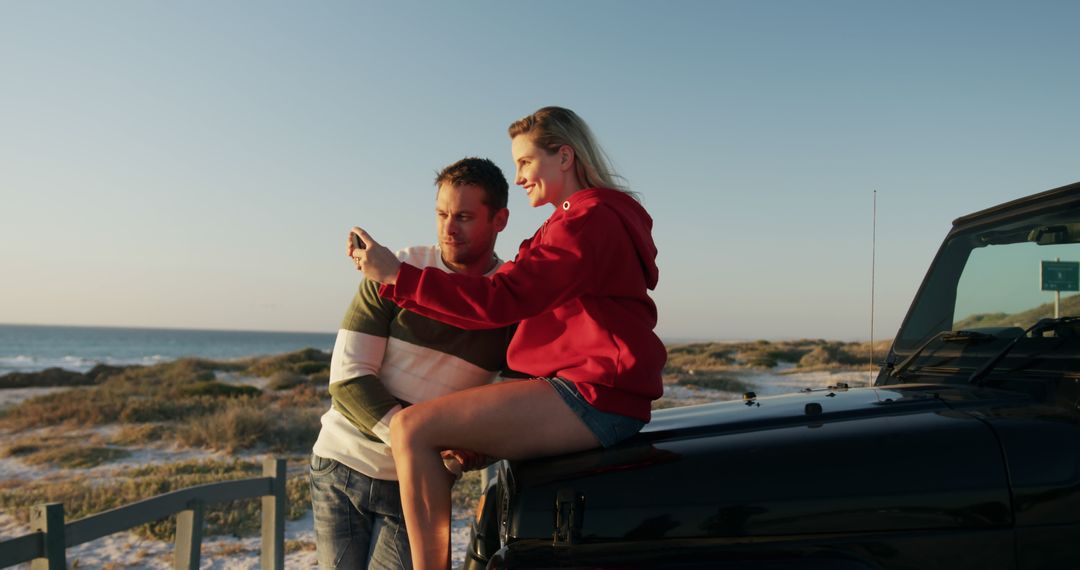 Couple Enjoying Sunset by the Beach with Smartphone - Free Images, Stock Photos and Pictures on Pikwizard.com