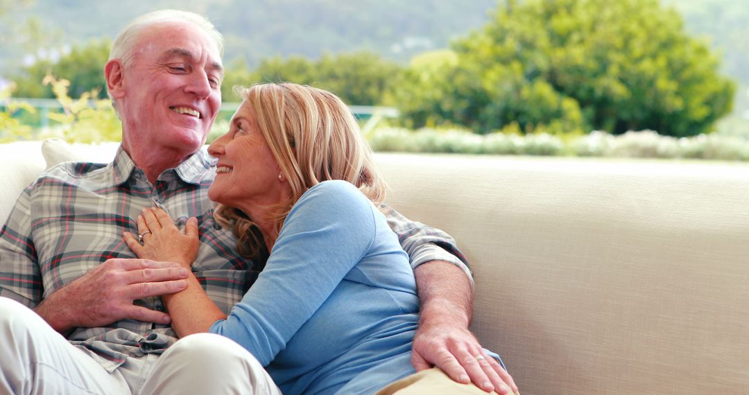 Happy Senior Couple Relaxing Together on Sofa in Sunny Room