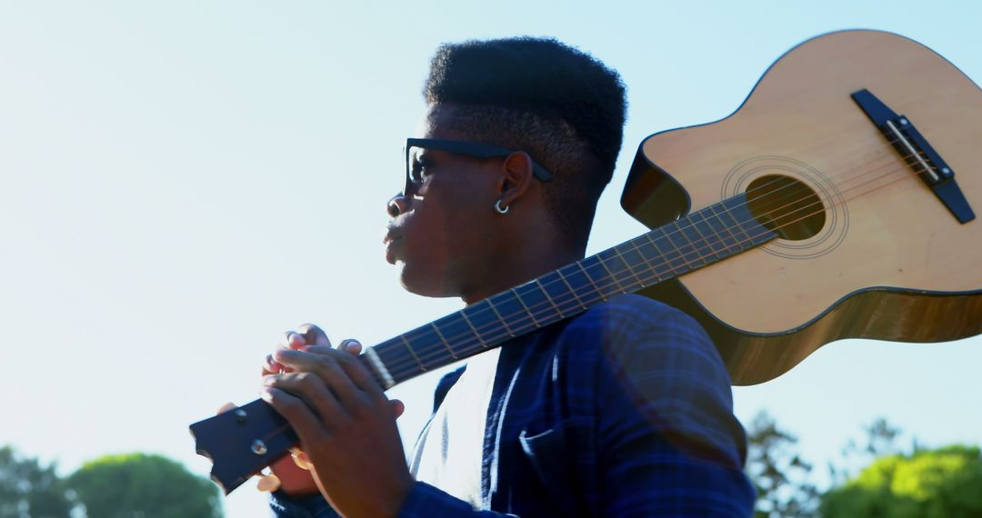 Young Musician Carrying Acoustic Guitar Outdoors in Daylight - Free Images, Stock Photos and Pictures on Pikwizard.com