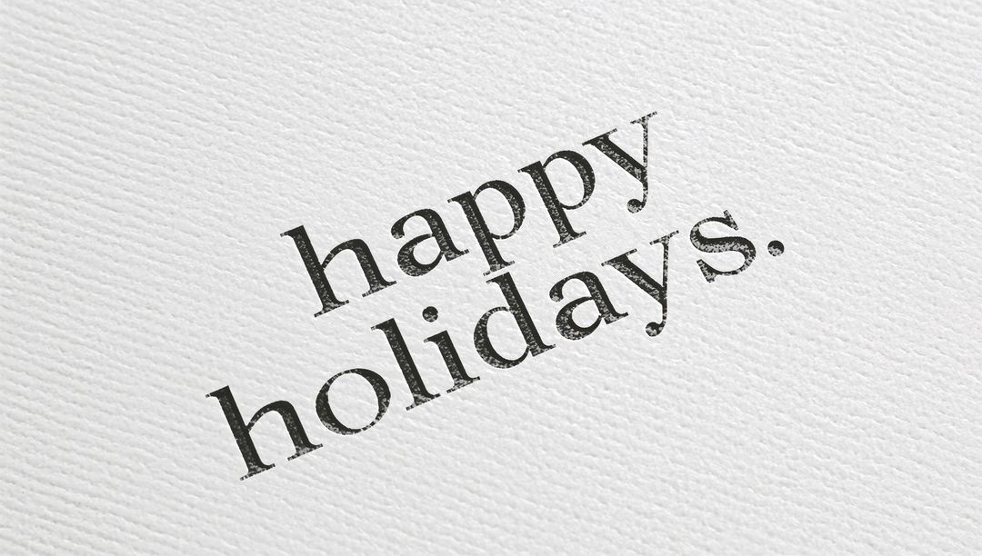 Minimal diagonal letterpress 'happy holidays.' on textured white cardstock with worn serif