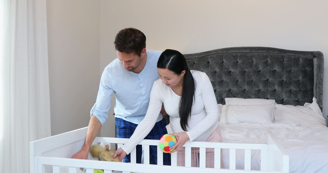 Expectant Parents Preparing Nursery Together with Toys