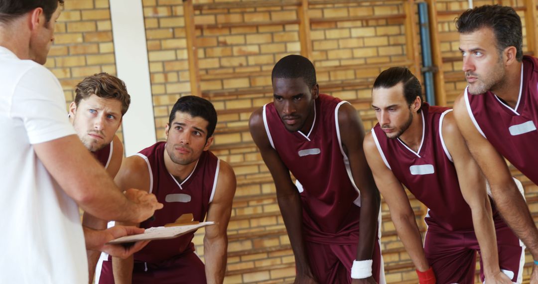 Basketball Coach Strategizing Team Game Plan in Gym
