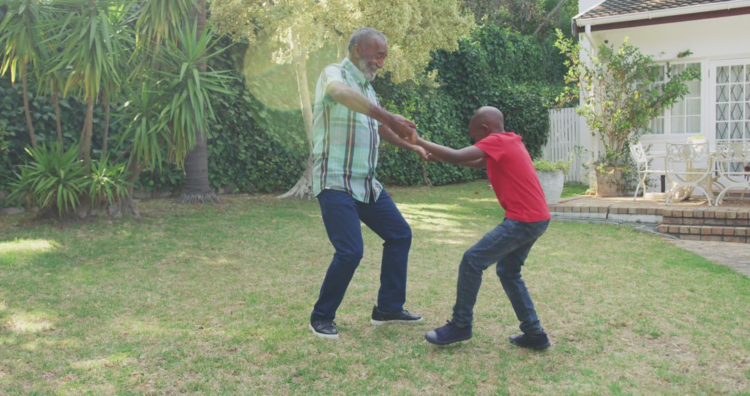Happy african american grandfather and grandson dancing in garden - Free Images, Stock Photos and Pictures on Pikwizard.com