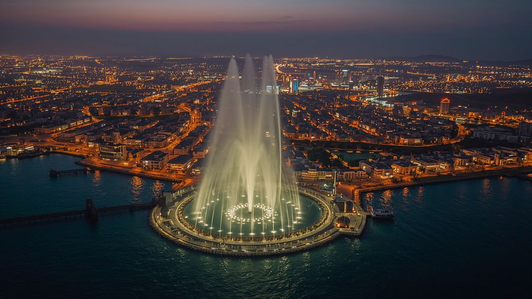 Mesmerizing Nighttime Illuminated Fountain Display on Coastline
